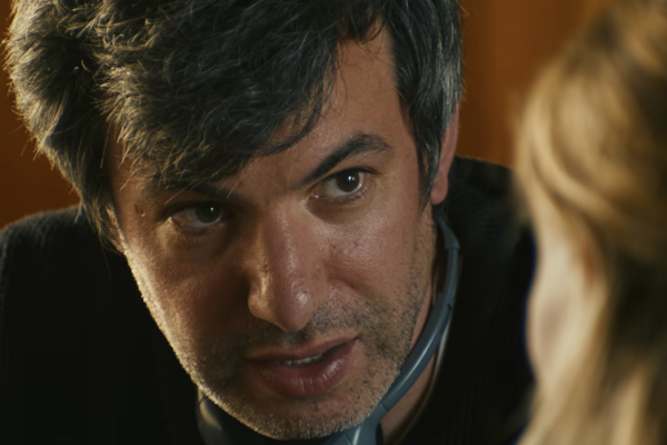 You Can See Everything Review: The Truth Is Not As Simple As It Seems Man in a black sweater staring at a blonde woman